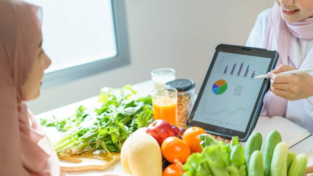 A woman discussing her diet chart with a dietitian, with fresh vegetables and fruit on the table
